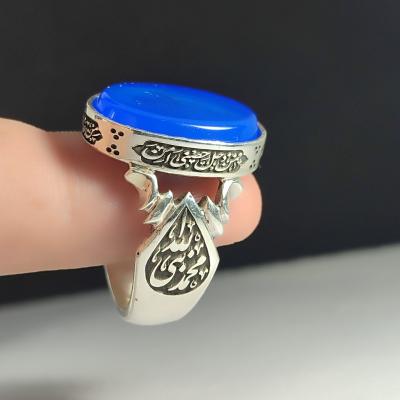 انگشتر نقره باسنگ عقیق آبی ذکر روی رکاب (ذکر ولایت امیر المومنین) ذکر بغل رکاب (محمدنبی الله) و (علی ولی الله) کد 2343