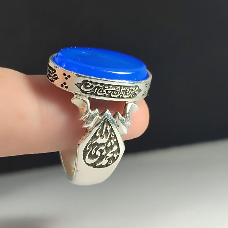 انگشتر نقره باسنگ عقیق آبی ذکر روی رکاب (ذکر ولایت امیر المومنین) ذکر بغل رکاب (محمدنبی الله) و (علی ولی الله) کد 2343